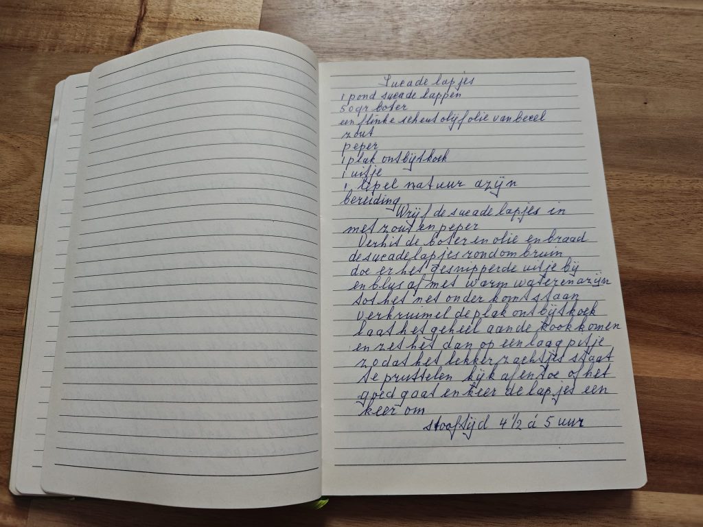 Handwritten Dutch recipe for “sucadelapjes” in a lined notebook on a wooden table